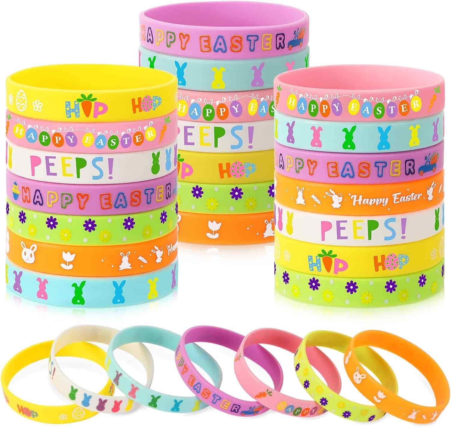 Colorful silicone bracelets with Easter-themed designs and phrases such as "HAPPY EASTER," "PEEPS," and "HOP," arranged in stacks and a row.