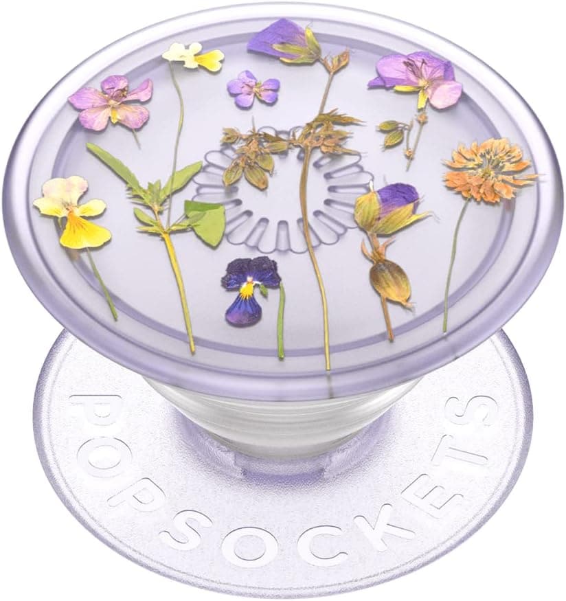 A lavender PopSocket grip featuring pressed flowers and leaves encased in a clear, round top with "PopSockets" embossed on the base.
