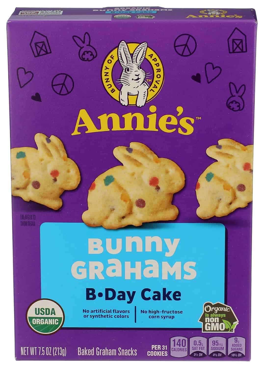 A purple box of Annie’s Bunny Grahams B-Day Cake baked graham snacks featuring images of bunny-shaped cookies and product details on the front.
