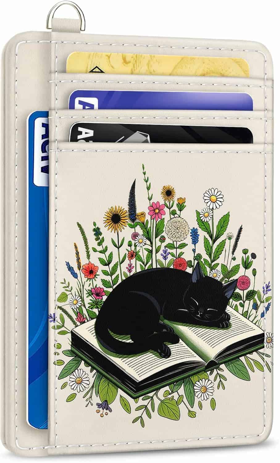 A beige cardholder with three cards and an illustration of a black cat sleeping on an open book surrounded by colorful wildflowers.