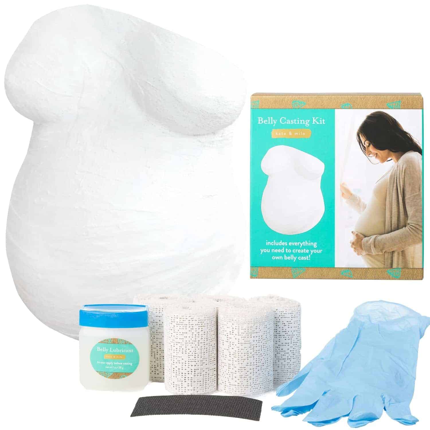 Belly casting kit with plaster strips, gloves, lubricant, sandpaper, and box packaging featuring an image of a pregnant woman and a finished belly cast.