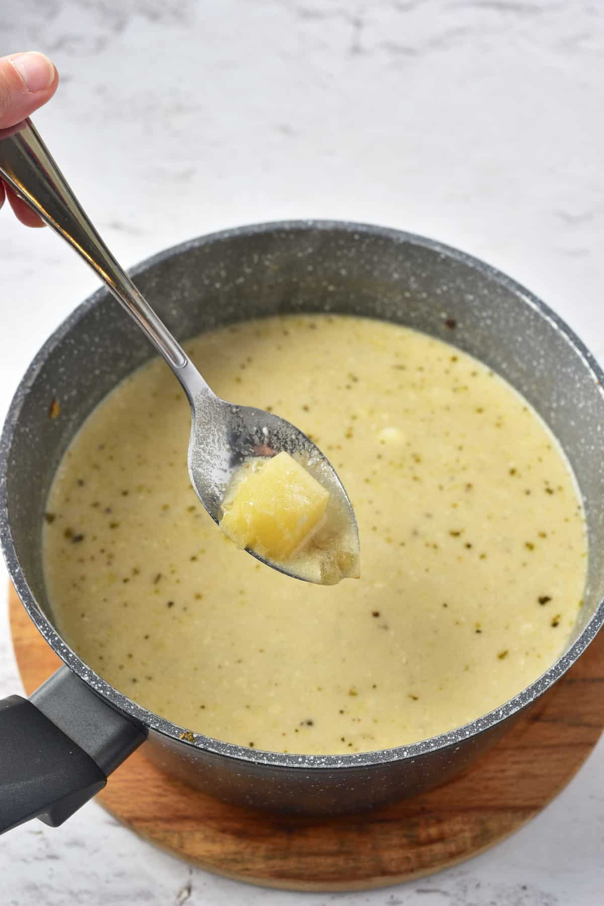 A spoon in a pot of soup.