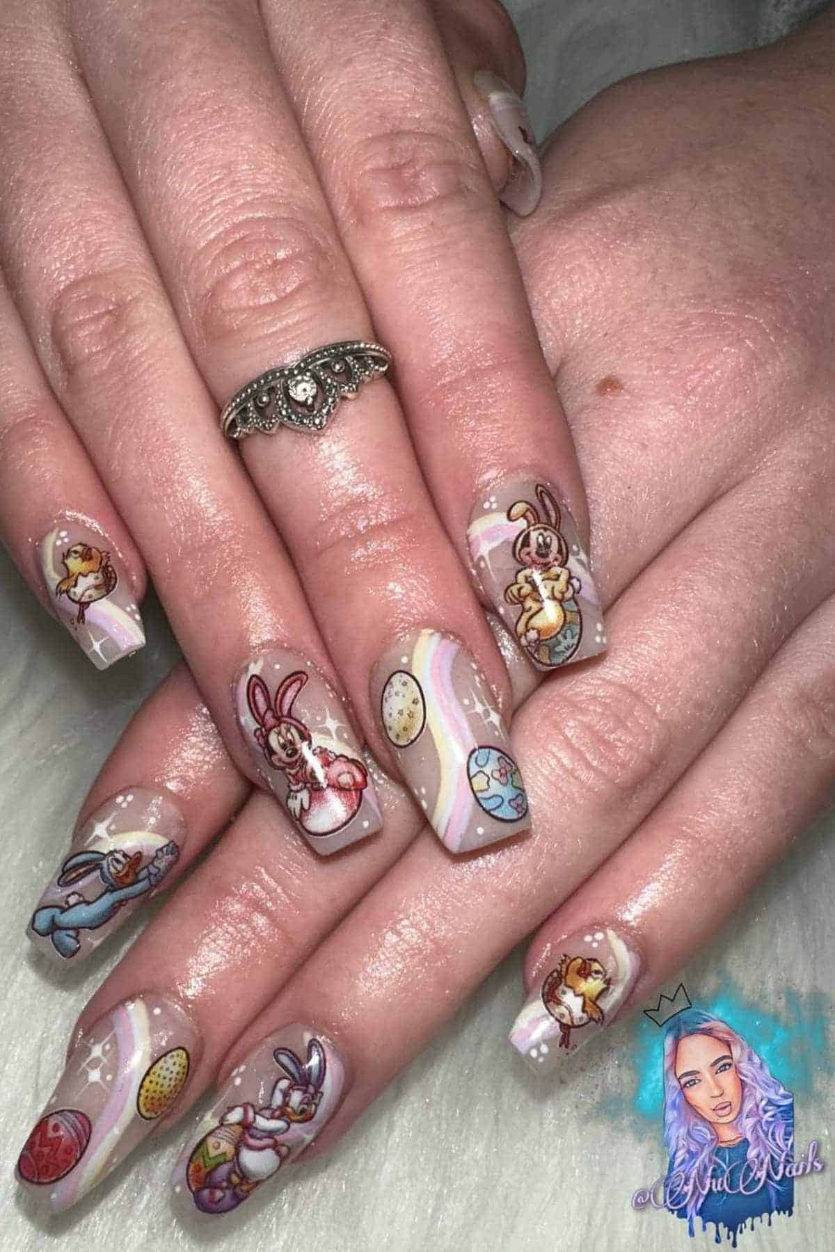 Close-up of hands with pastel Easter-themed nail art featuring rabbits, eggs, and swirled patterns on long square-shaped nails.