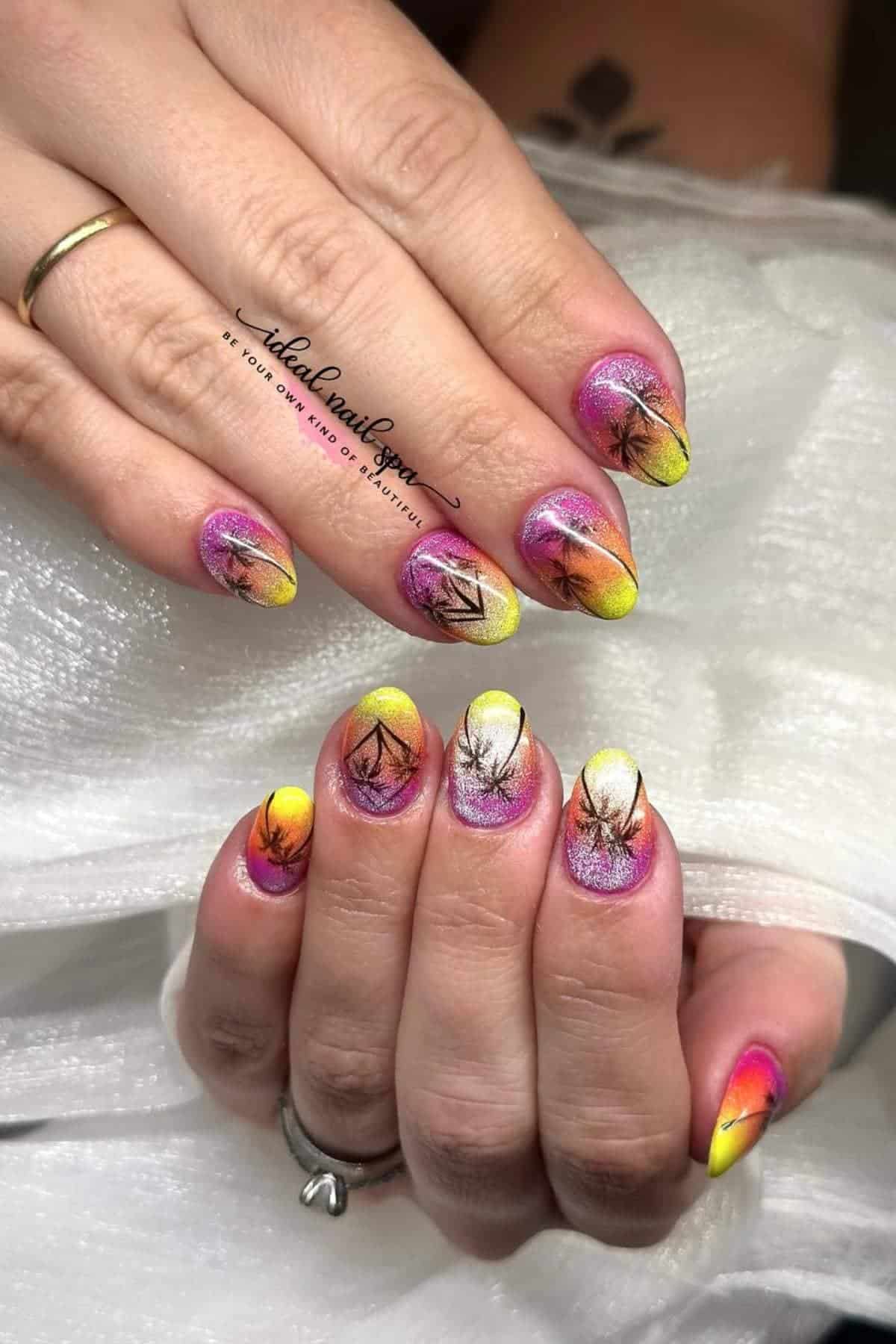 Hands with almond-shaped nails featuring a gradient design in pink, yellow, and orange shades, with black geometric and leaf-like line art on each nail.