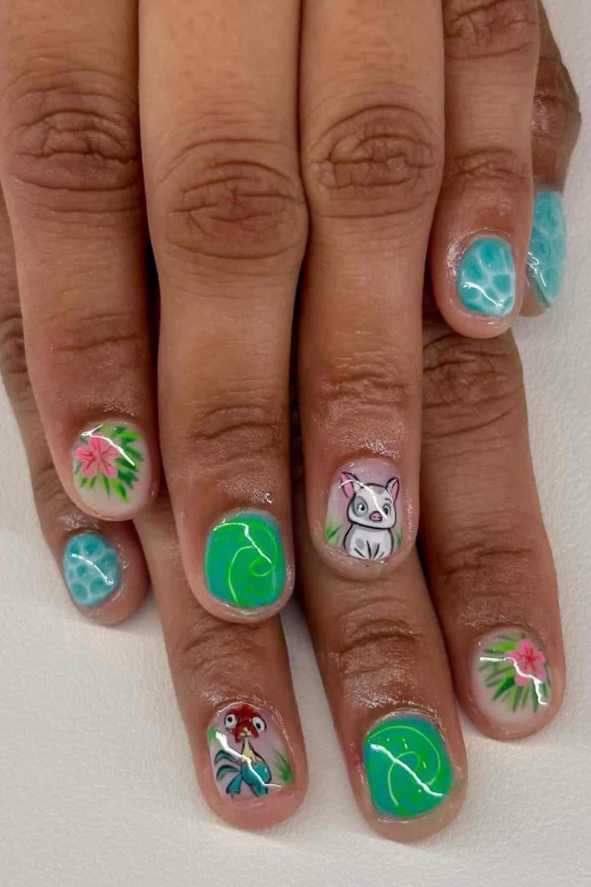 Fingernails with turquoise and green designs, featuring flowers, a cartoon pig, and a crab on a white background.