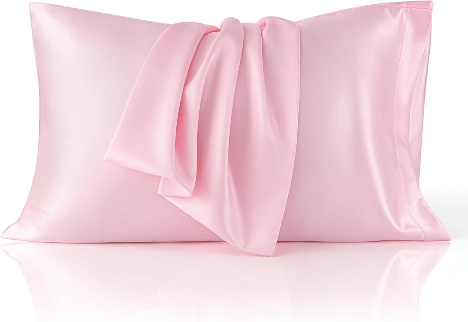 A light pink satin pillowcase with a matching pink satin sleep mask draped over it, displayed on a white surface.