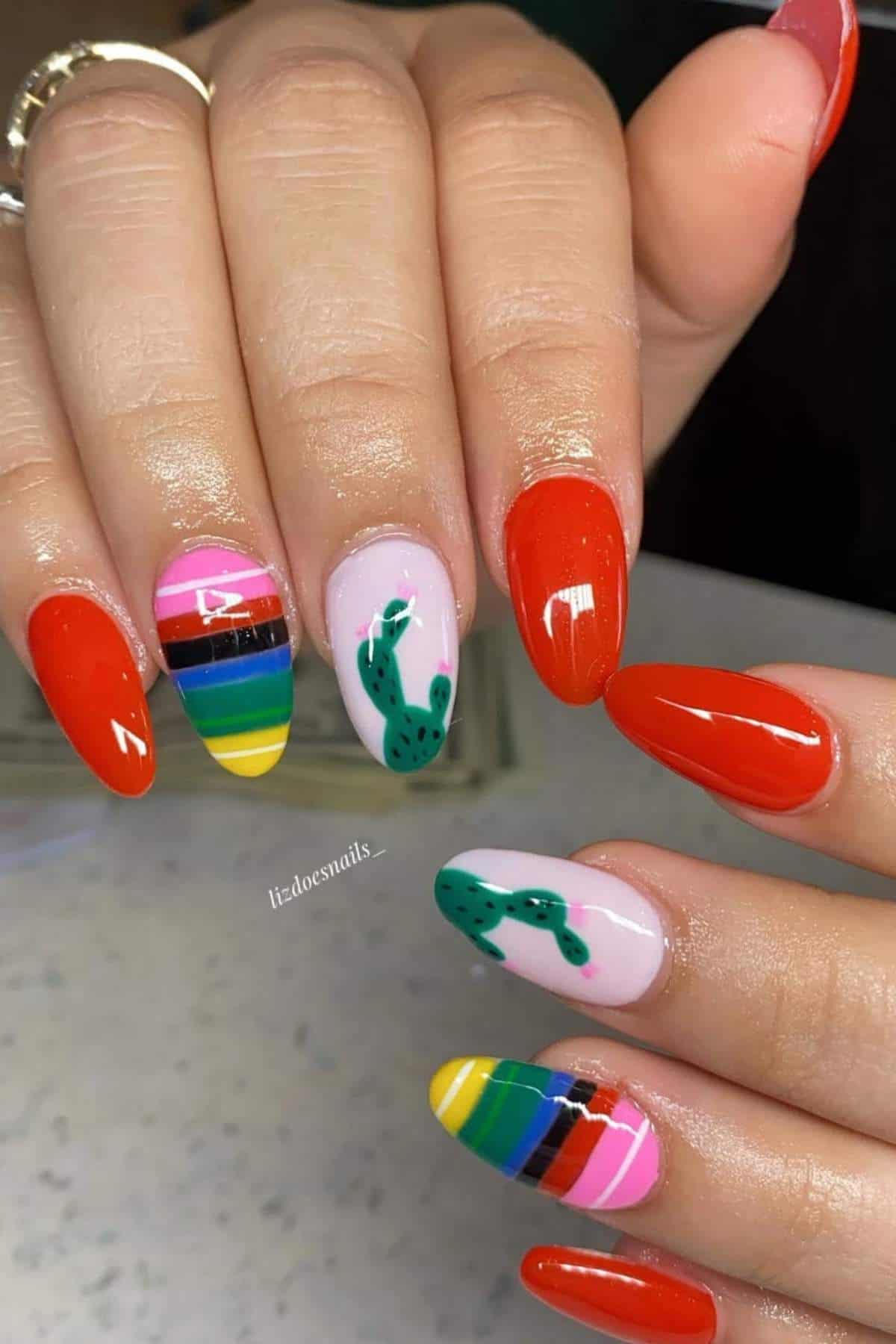 Hands with long, almond-shaped nails featuring bright red polish, two with colorful stripes, and two with green cactus nail art on a white background.