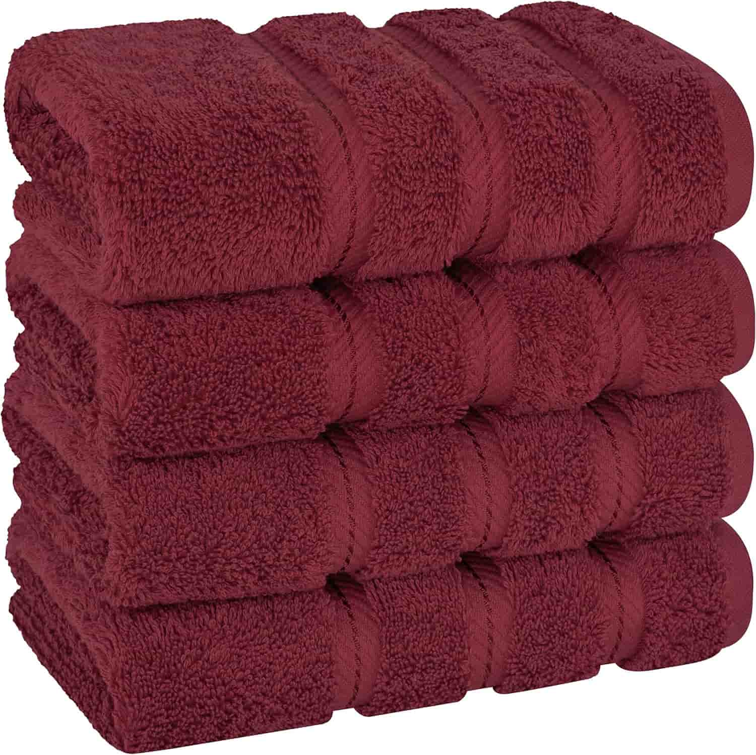 A stack of six folded, burgundy-colored towels arranged neatly on top of each other.