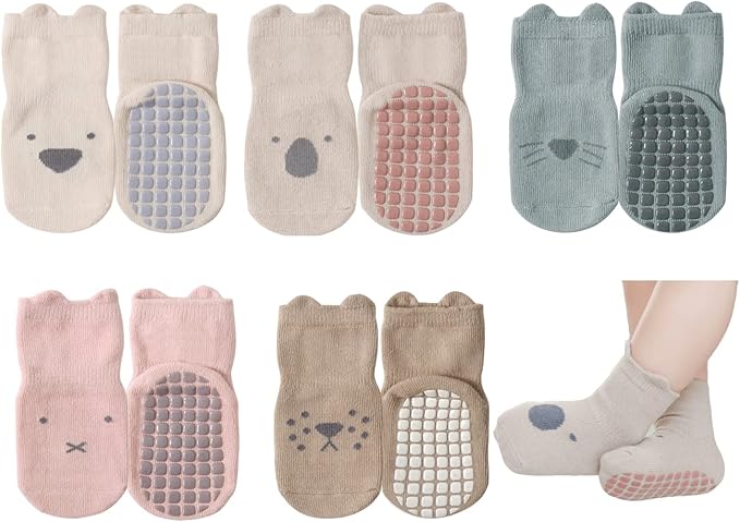 Eight pairs of baby socks in various pastel colors with animal faces and non-slip grips on the soles; one pair is shown worn on a child's feet.