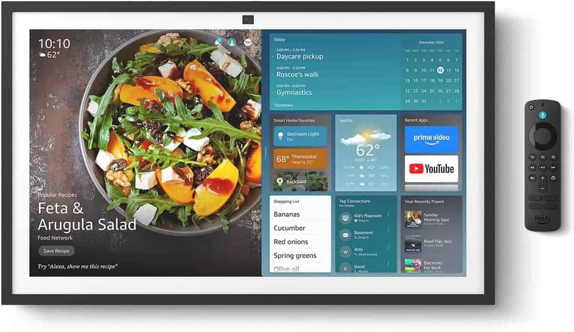 A smart display screen showing a digital recipe for feta and arugula salad, weather updates, calendar events, smart home controls, a shopping list, and streaming app icons, with a remote beside it.