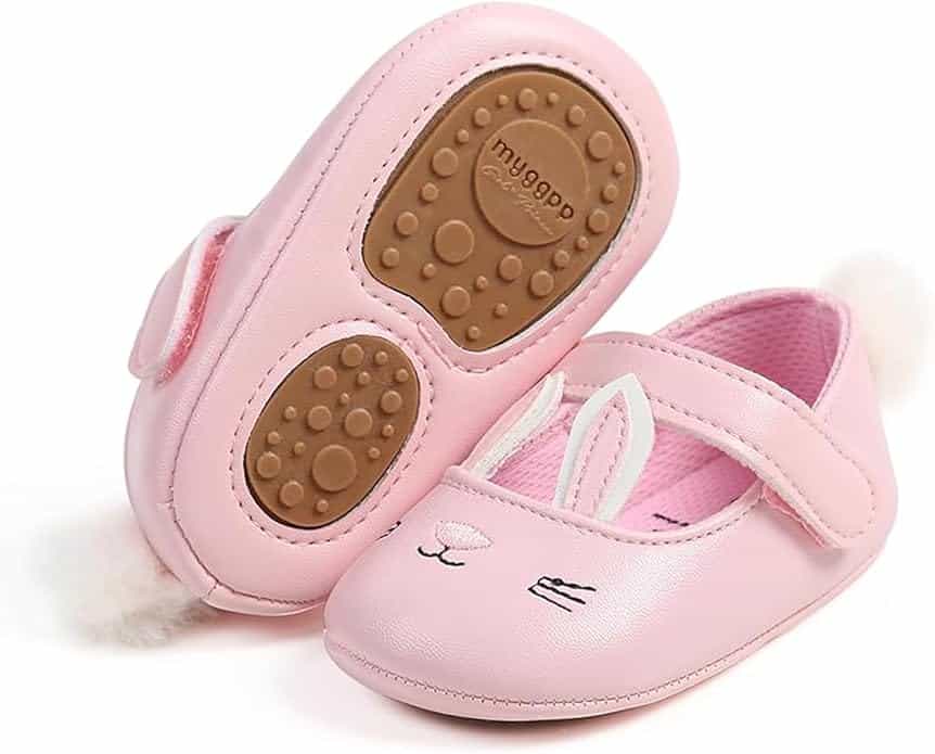 Pair of pink baby shoes with bunny face and ear designs, velcro straps, and rubber soles featuring paw print patterns; brand name "mugpop" on the sole.