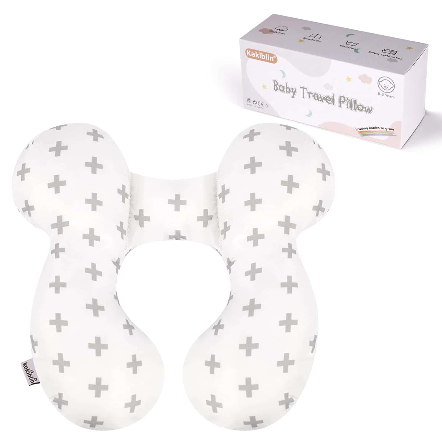White baby travel pillow with gray plus sign pattern, shaped to support a baby's neck, shown next to its packaging box labeled "Kakiblin Baby Travel Pillow.