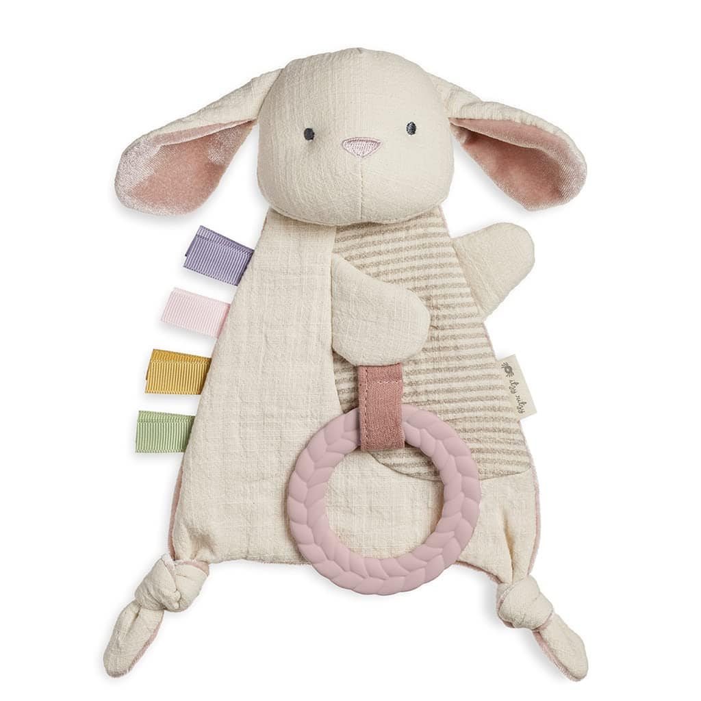 Plush bunny baby comforter with floppy ears, pastel ribbon tags, striped fabric detail, knotted corners, and a pink textured teething ring attached.