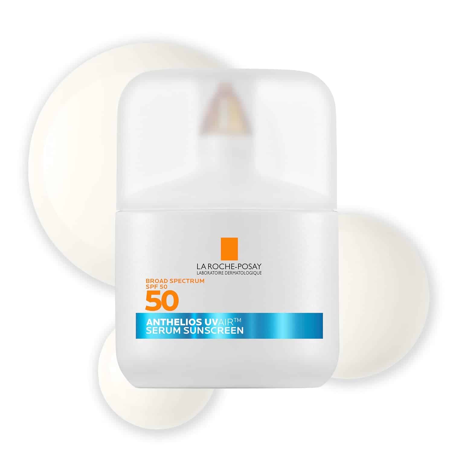 A white bottle of La Roche-Posay Anthelios Uvairt Serum Sunscreen SPF 50 with a blue label, shown with swatches of the product in the background.