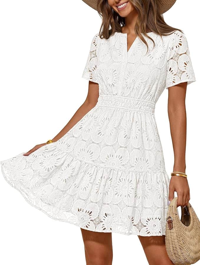 Woman wearing a short-sleeved, white lace dress with a flared skirt, accessorized with a straw hat, bracelets, and a woven handbag.