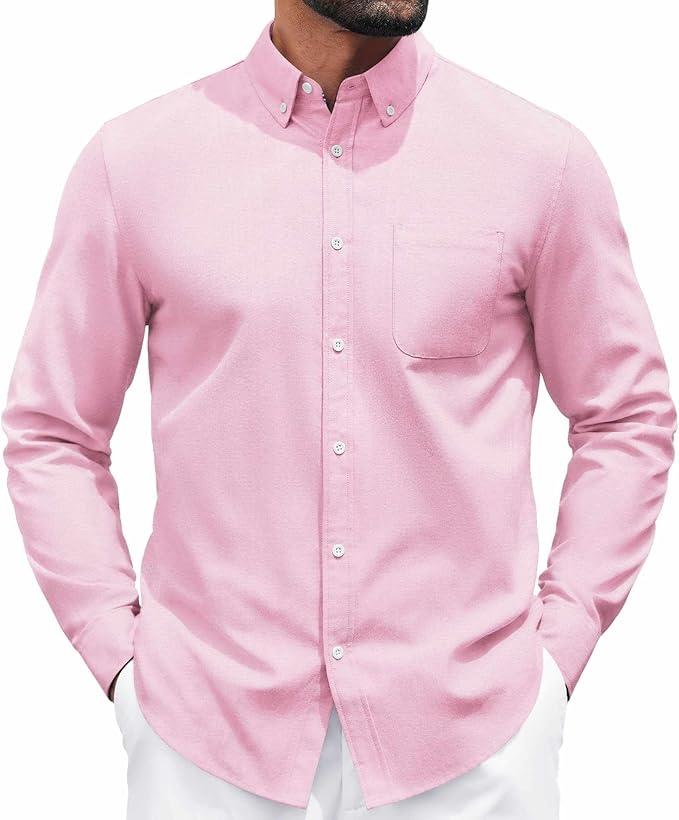 A man wearing a light pink, long-sleeve, button-down shirt with a front pocket, paired with white pants.