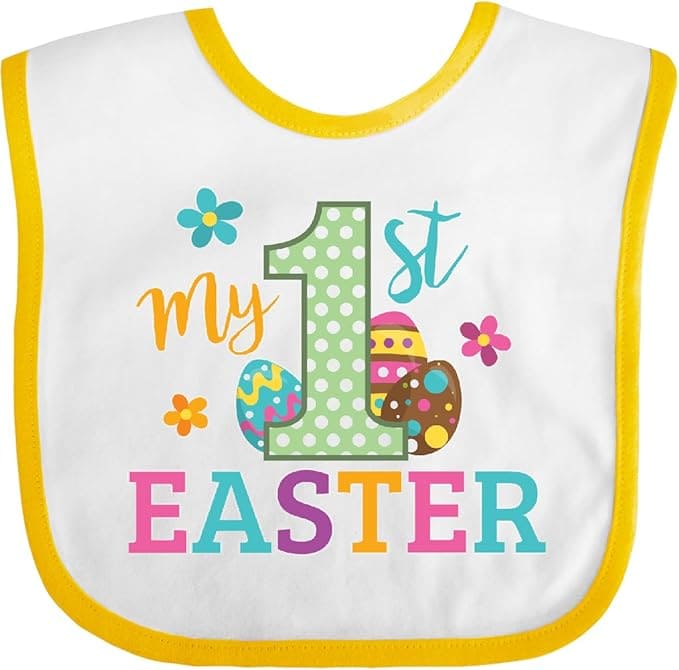 White baby bib with yellow trim, featuring the text "my 1st EASTER" and decorated with colorful eggs and flowers.