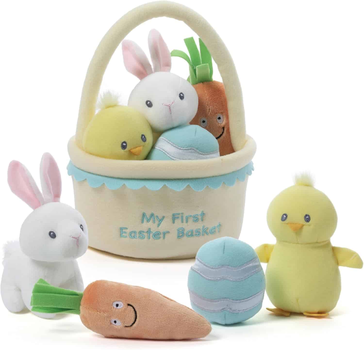 A plush Easter basket labeled "My First Easter Basket" with stuffed toys including a bunny, chick, carrot, and egg, arranged in front and inside the basket.