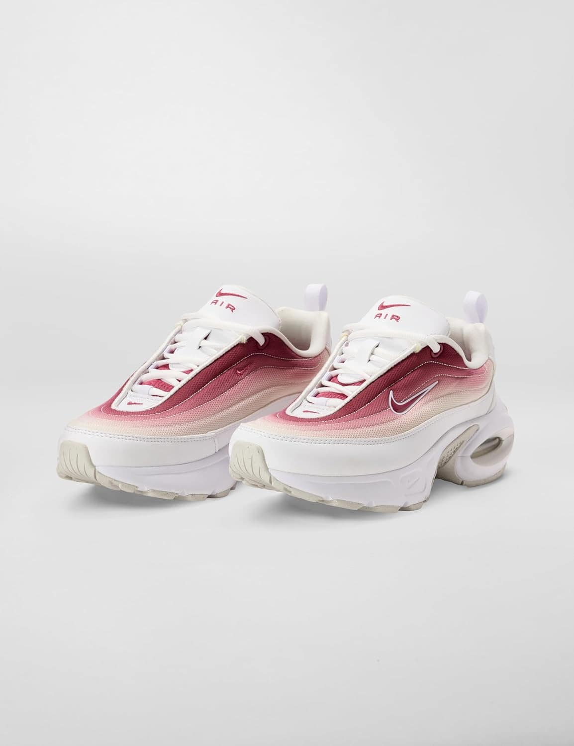 A pair of Nike Air Max sneakers with a white and gradient red upper, chunky white sole, and visible air cushioning, displayed against a plain background.