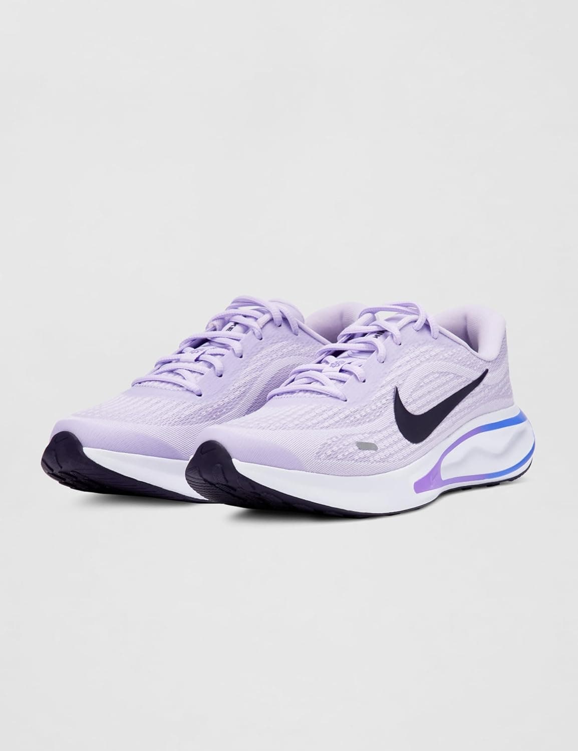 A pair of light purple Nike running shoes with black swooshes, white soles, and purple accents, displayed on a plain light background.