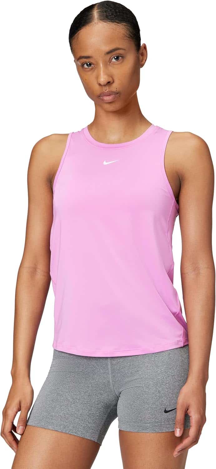 A person wearing a sleeveless pink Nike top and gray Nike shorts stands facing forward against a plain background.