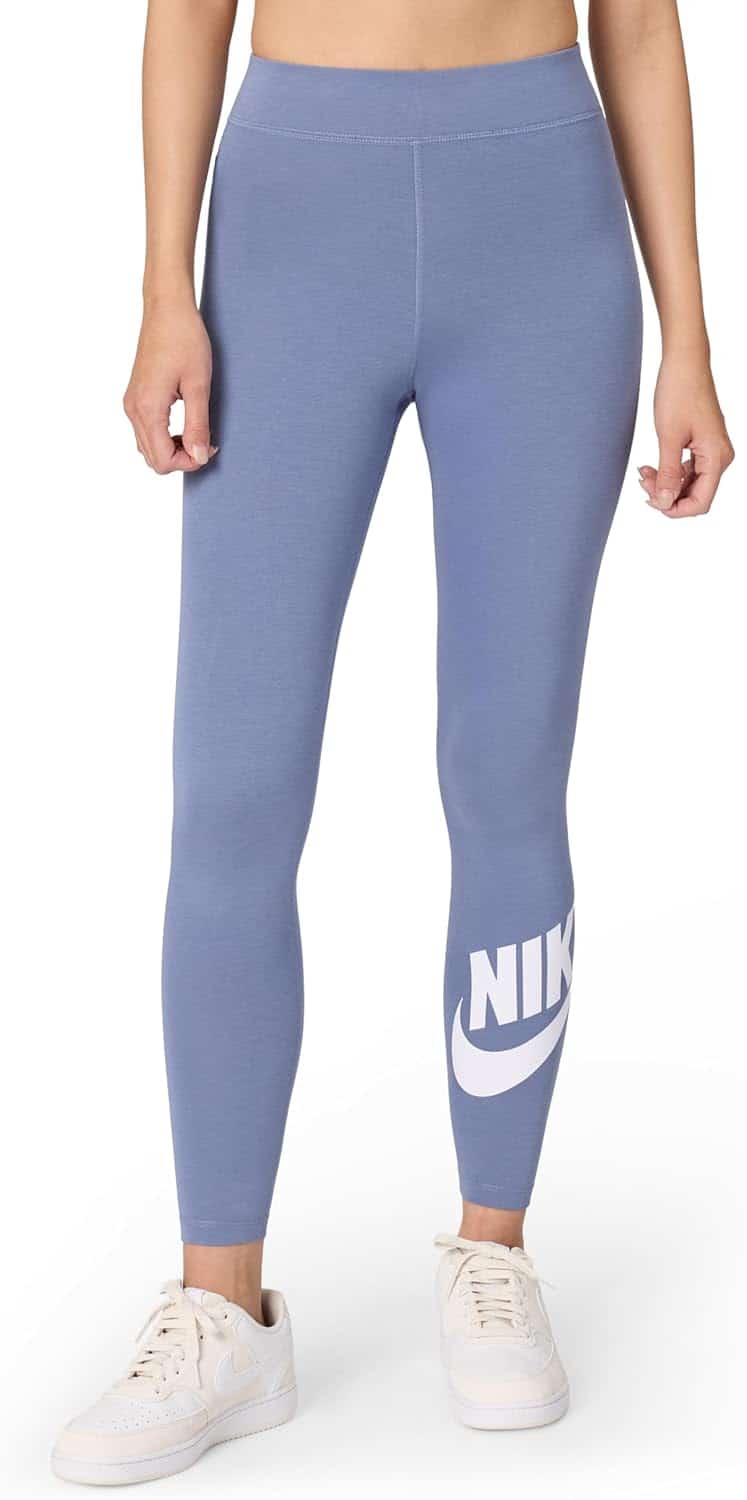 A person wearing light purple Nike leggings with a white Nike logo on the lower leg and white sneakers, standing against a plain background.