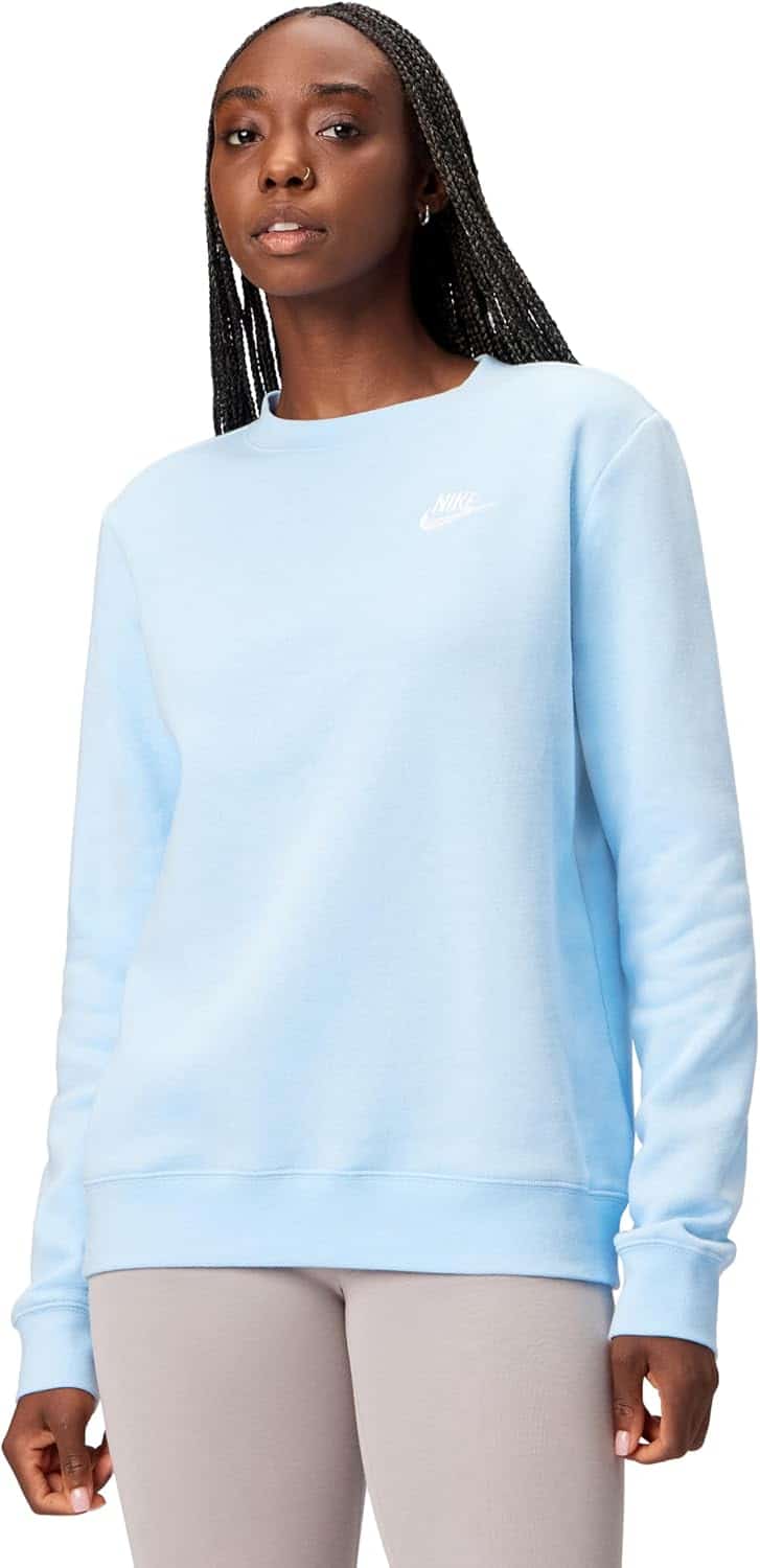 A person wearing a light blue Nike sweatshirt and light gray leggings stands against a white background.