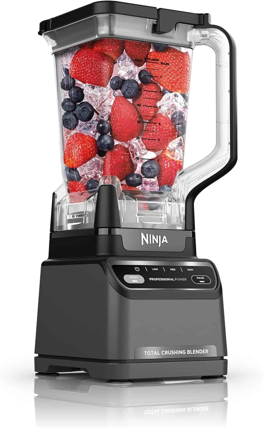 A Ninja blender filled with ice, strawberries, raspberries, blueberries, and blackberries, shown against a white background.