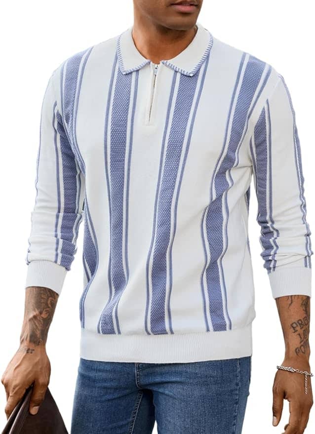 Man wearing a white long-sleeve sweater with vertical blue stripes and a zip collar, paired with blue jeans and holding a dark-colored bag.