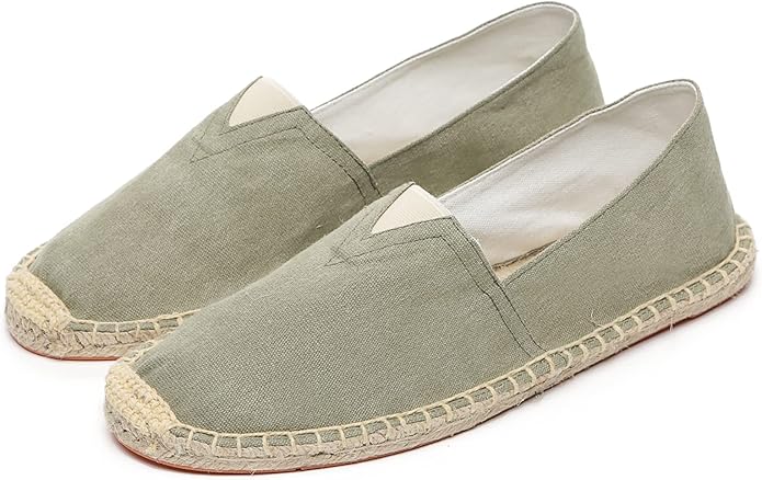 A pair of light olive green canvas slip-on espadrille shoes with woven jute soles and stitched details.