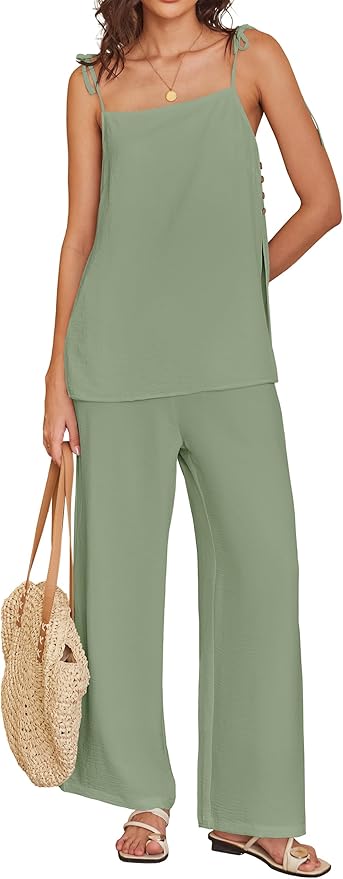 Woman wearing a sage green sleeveless top and wide-leg pants, holding a woven straw bag, and wearing sandals.