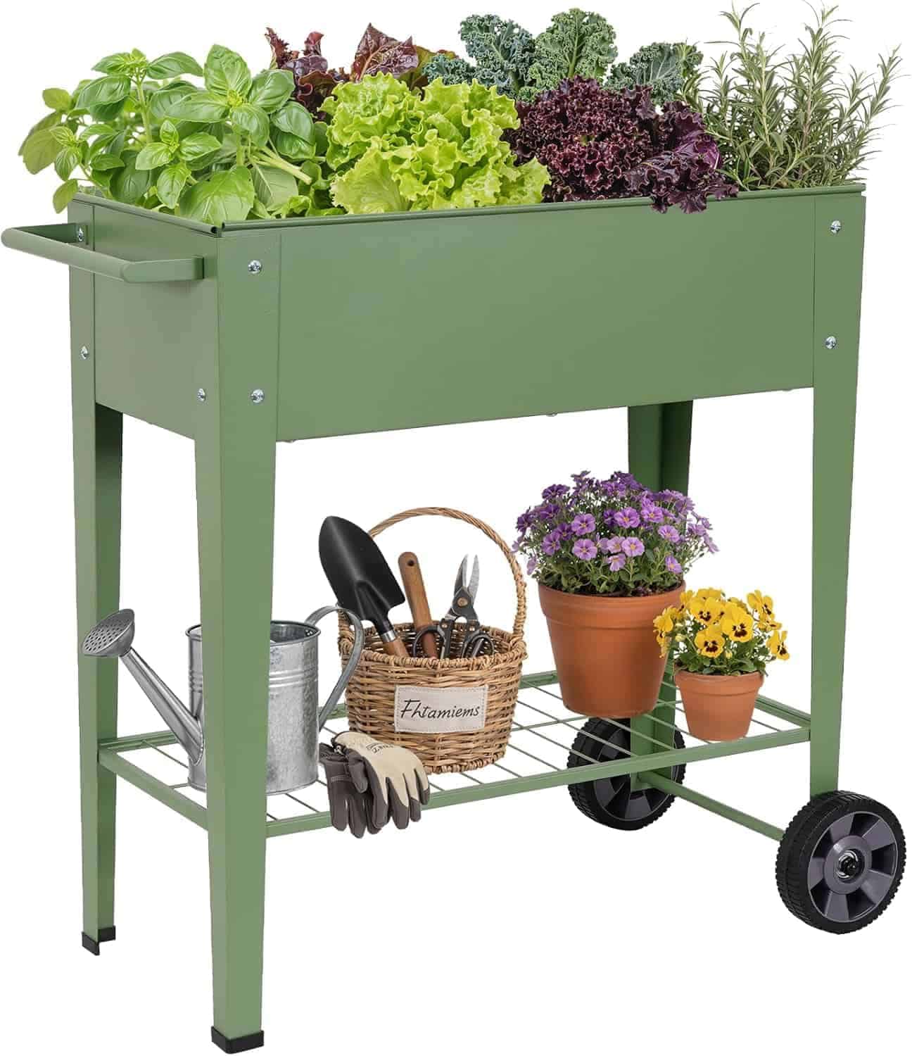 Green raised garden bed on wheels with various herbs and leafy greens on top, and gardening tools, watering can, gloves, and potted flowers stored on the bottom shelf.