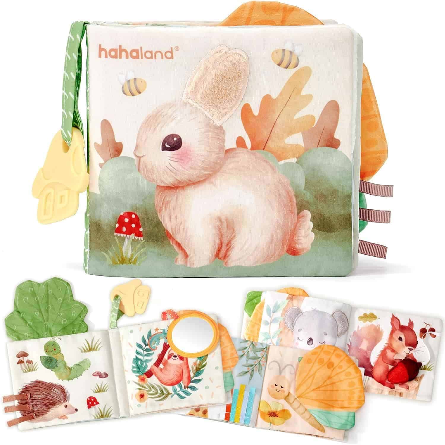 Illustrated soft baby book with animal images, textured tags, teether, and interactive elements, featuring a rabbit on the cover and various woodland animals on inside pages.