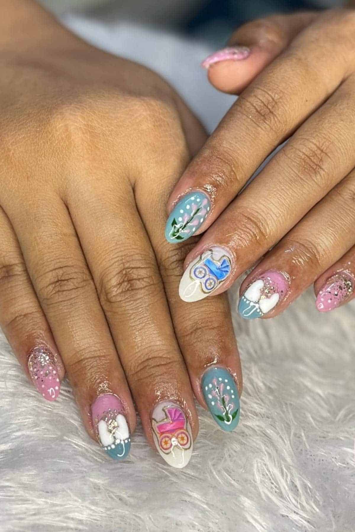 Two hands with long, almond-shaped nails featuring pastel colors, floral designs, glitter, and 3D bows on some nails, resting on a white textured surface.