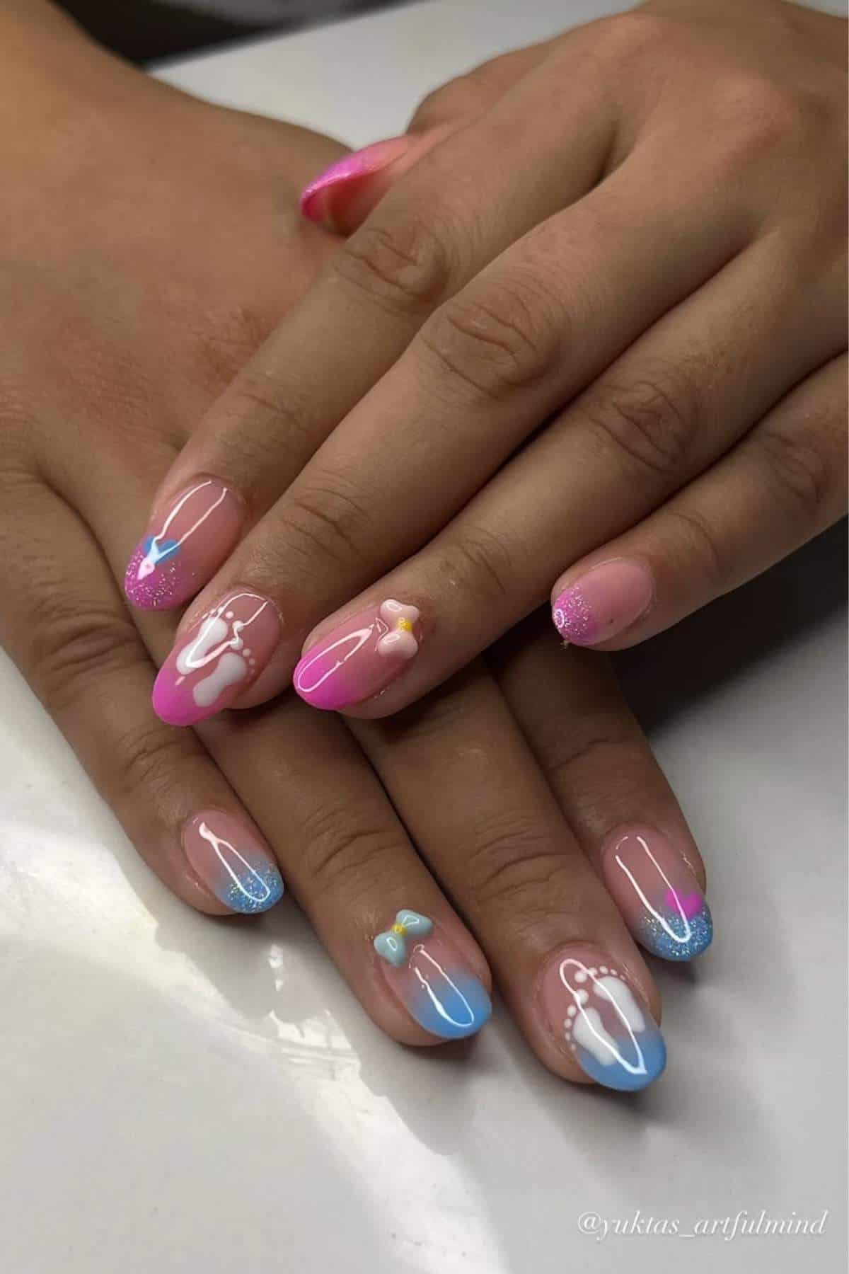 Hands with long almond-shaped nails featuring a pink and blue gradient design, white abstract lines, and small bow-shaped embellishments on two nails.