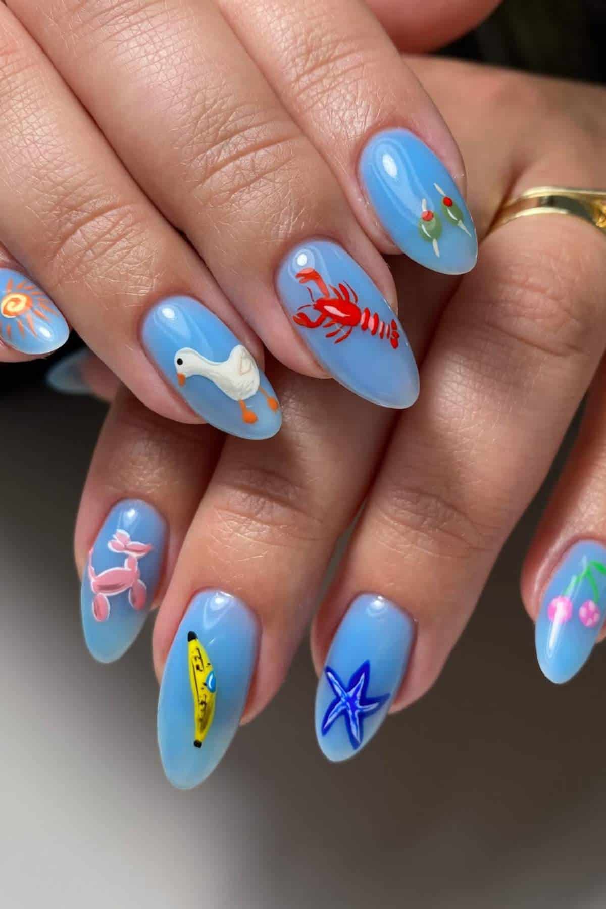 A hand with light blue nail polish featuring detailed designs of a goose, lobster, flowers, starfish, banana, and a pink dog on each fingernail.