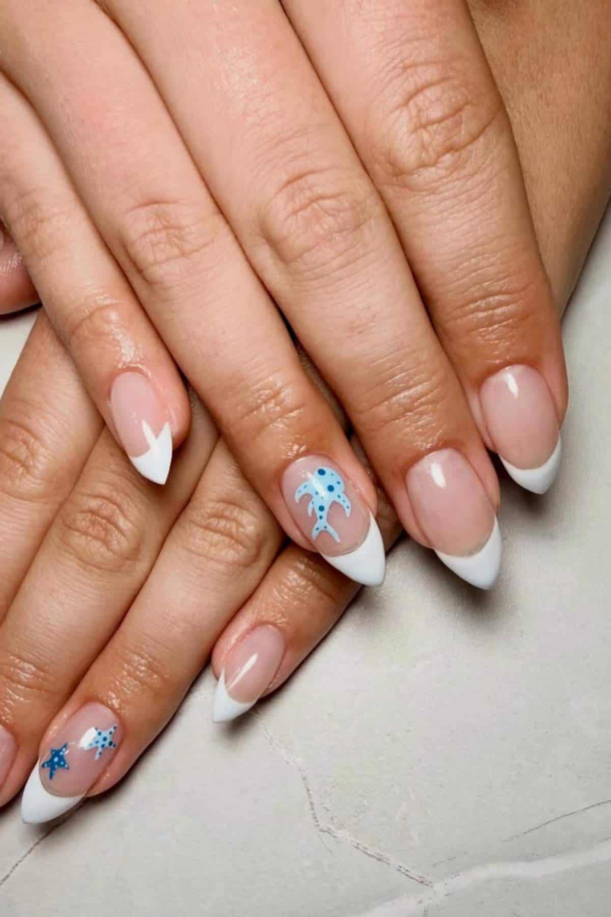 Hands with almond-shaped French manicure; two nails feature blue stingray nail art.