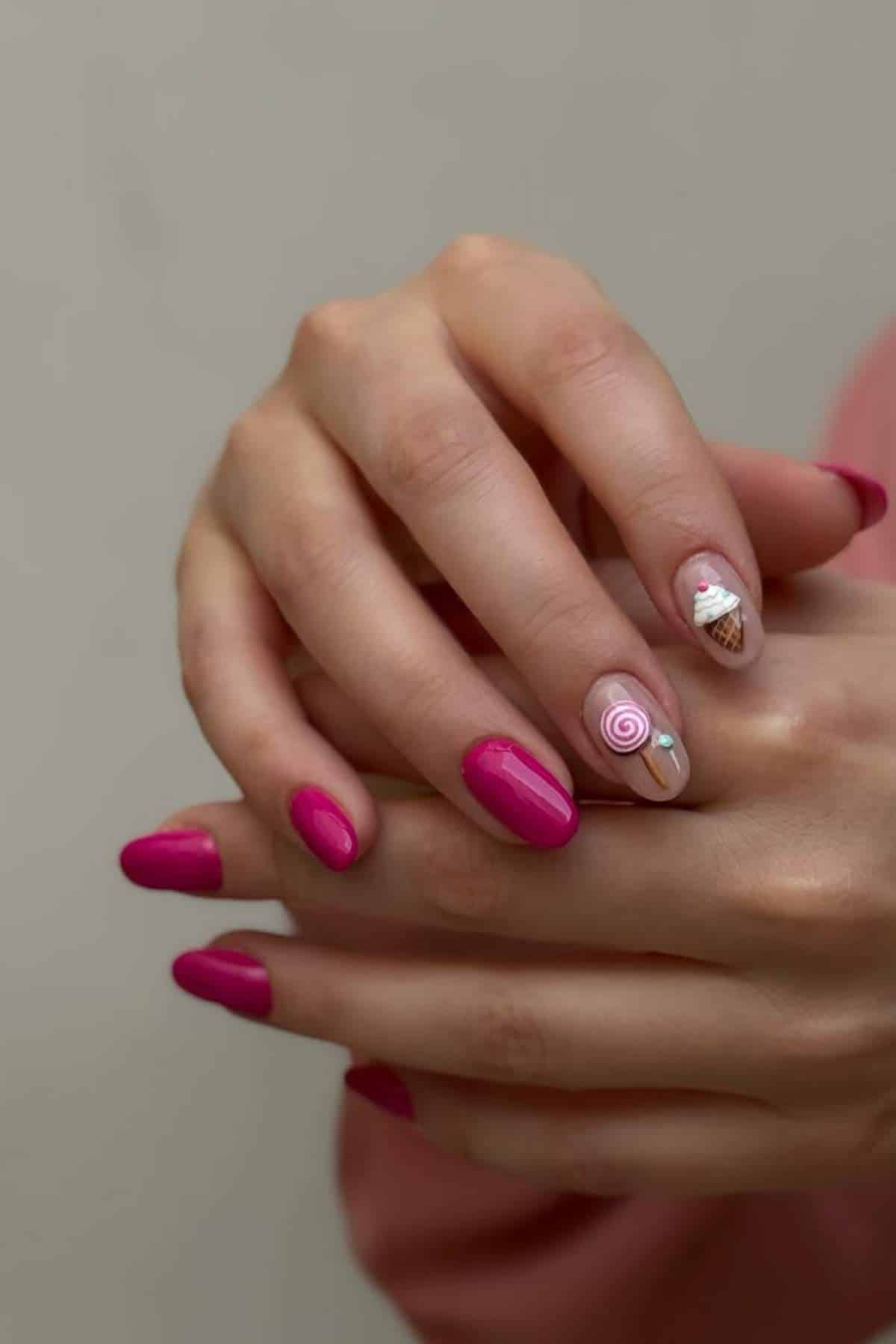 Hands with pink manicured nails, featuring detailed nail art on two fingers: one with a pink swirl and the other with an ice cream cone design.