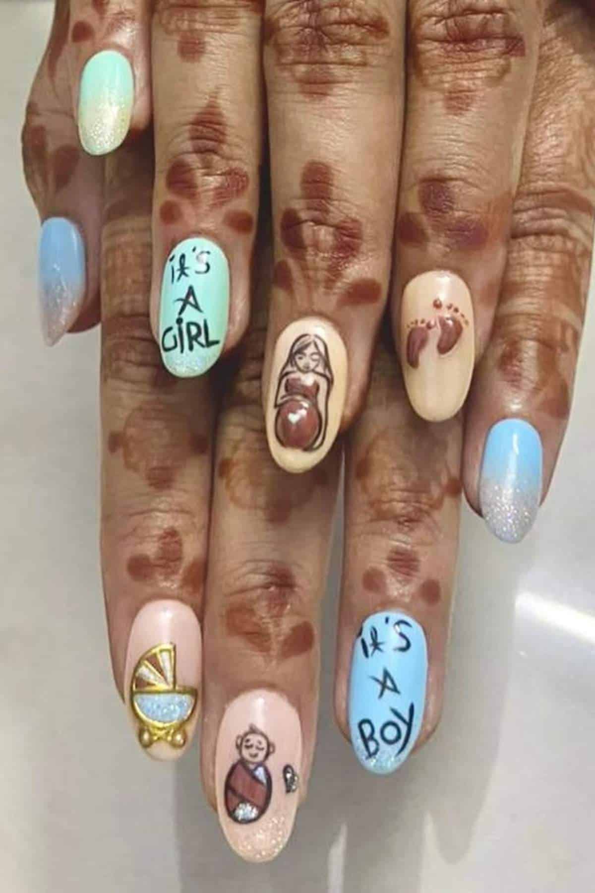 Hands with henna designs display manicured nails featuring baby-themed art, including "It's a Girl," "It's a Boy," a swaddled baby, a crib, a pregnant woman, and baby footprints.