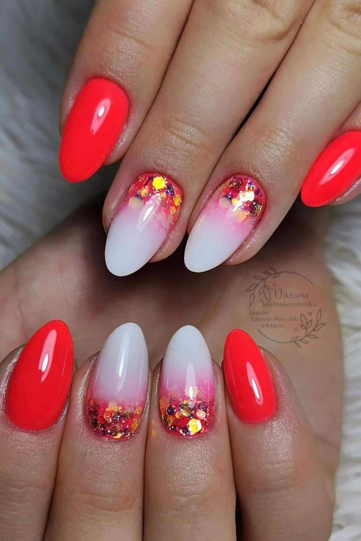 Close-up of hands with almond-shaped nails featuring neon coral polish, white-to-pink ombre tips, and glitter accents on the middle and ring fingers.