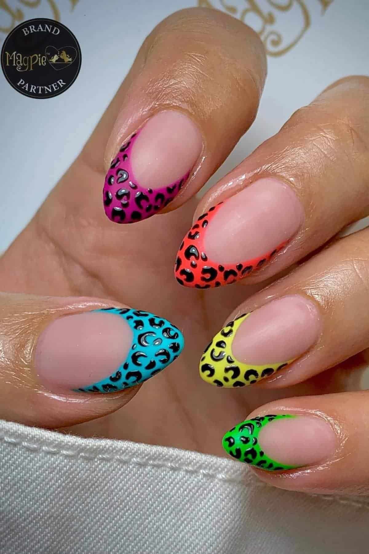 A hand with almond-shaped nails featuring colorful neon French tips and black leopard print accents on each tip.