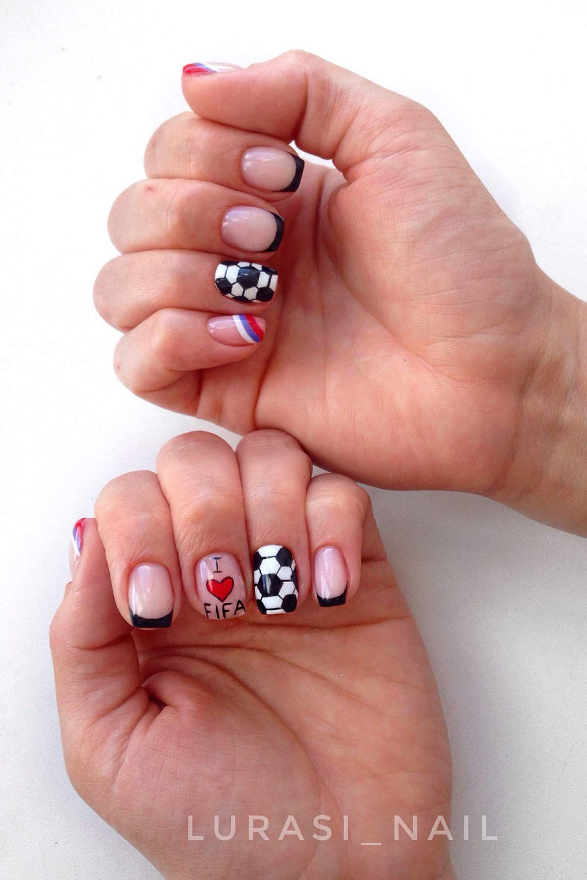 Close-up of hands with nail art featuring soccer balls, "I ♥ FIFA" text, and red, white, and blue stripes on a few nails.