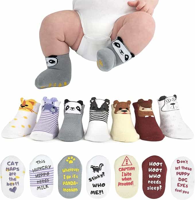 A baby wearing panda-themed socks sits above a row of eight pairs of animal-themed baby socks, each with different animal faces and playful text on the soles.