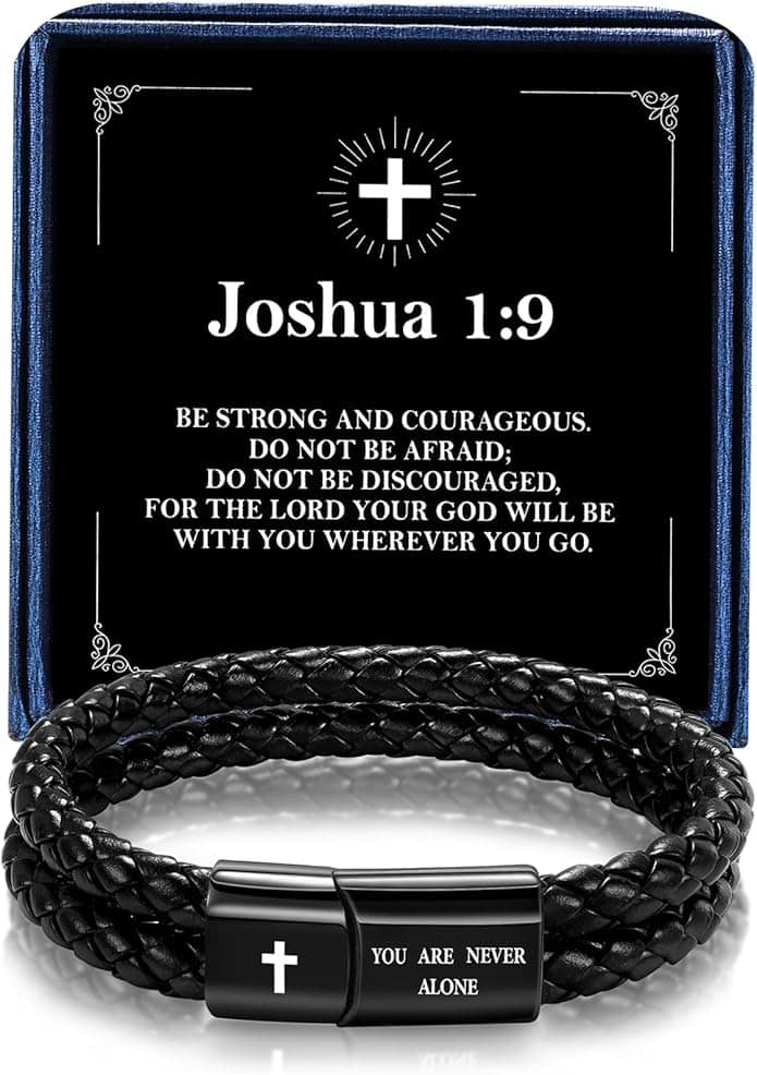 A braided black bracelet with a cross and the words "You are never alone," placed in front of a card displaying Joshua 1:9 Bible verse.