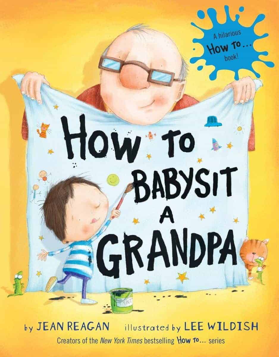 A smiling man holds a blanket with a child; the blanket reads "How to Babysit a Grandpa." The book is by Jean Reagan, illustrated by Lee Wildish. A cat and toys are nearby.