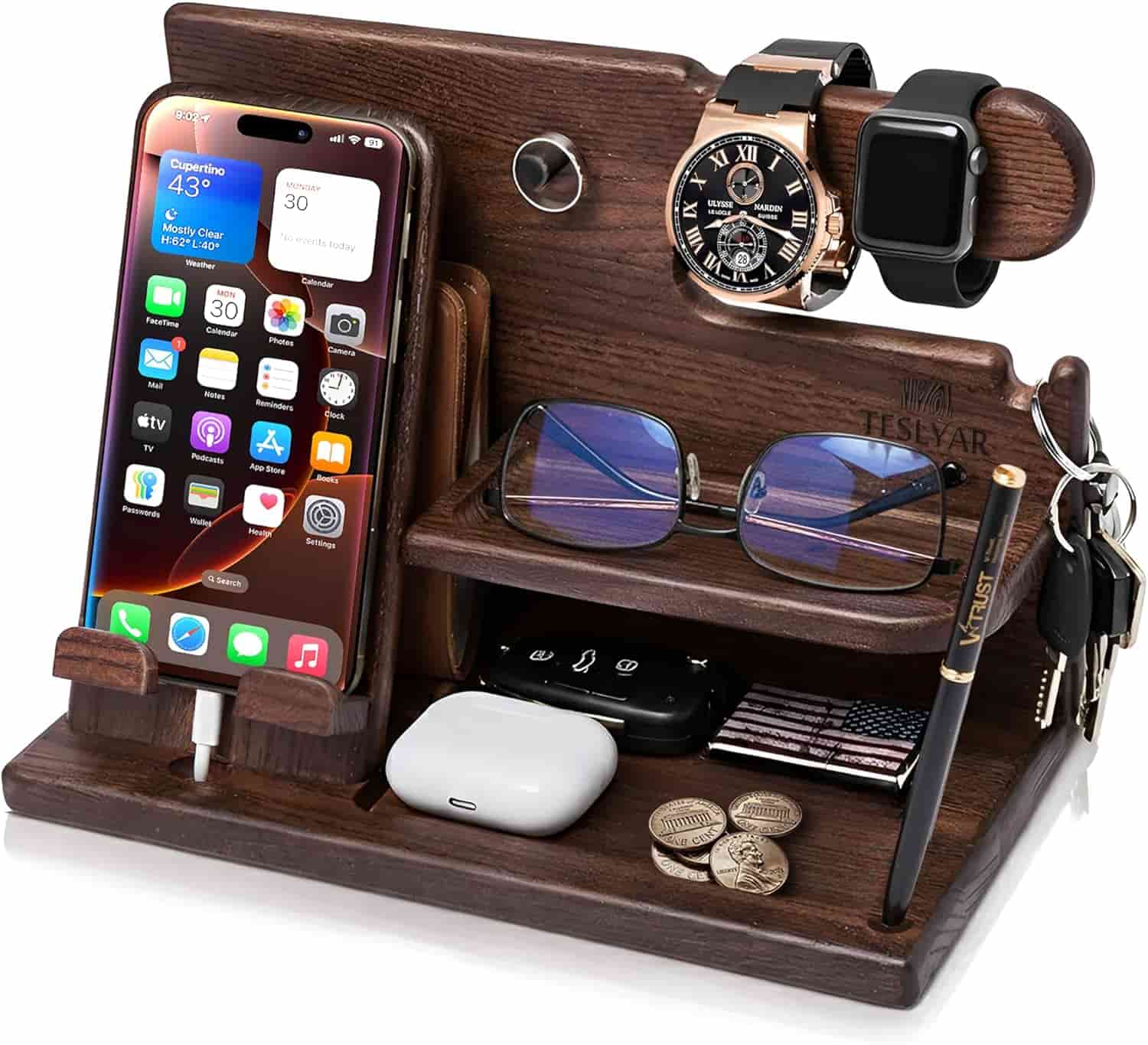 A wooden organizer holding a smartphone, two watches, glasses, keys, a pen, AirPods, and a wallet.