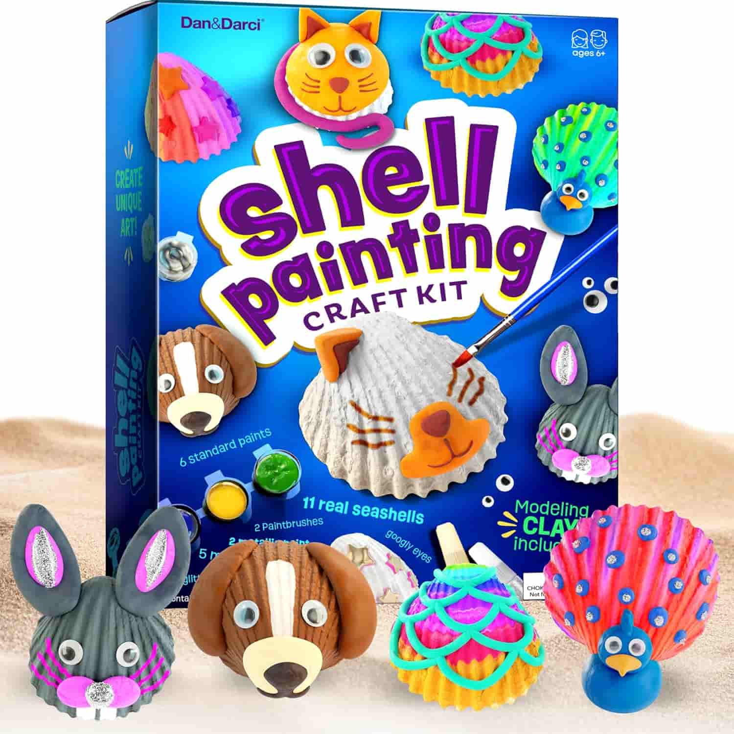 Shell painting craft kit box with illustrated seashell animals, paint pots, and four completed animal shell figures including a bunny, dog, cat, and peacock displayed in front.