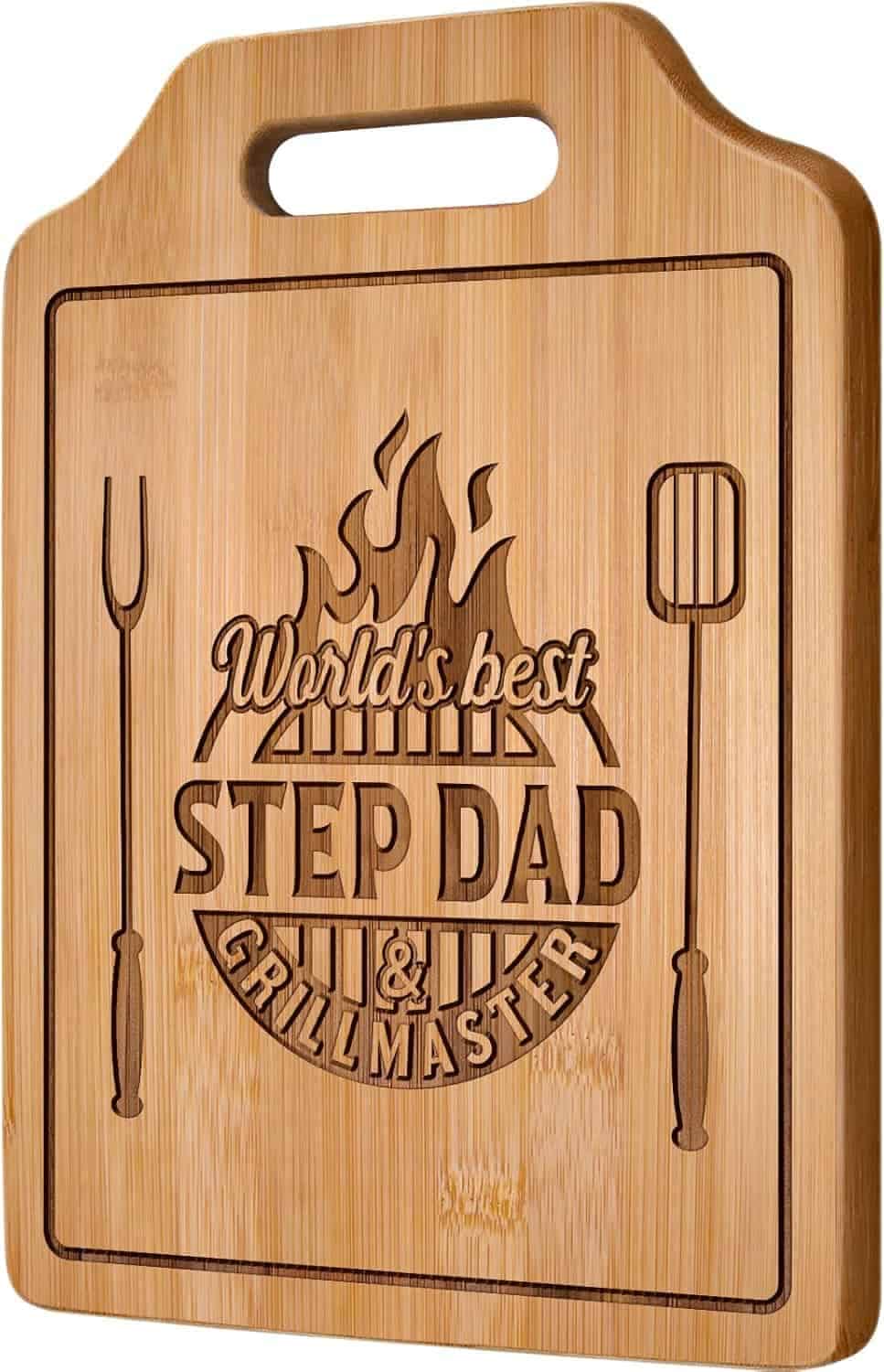 A wooden cutting board engraved with the text "World's Best Step Dad & Grill Master" alongside images of a grilling fork and spatula.
