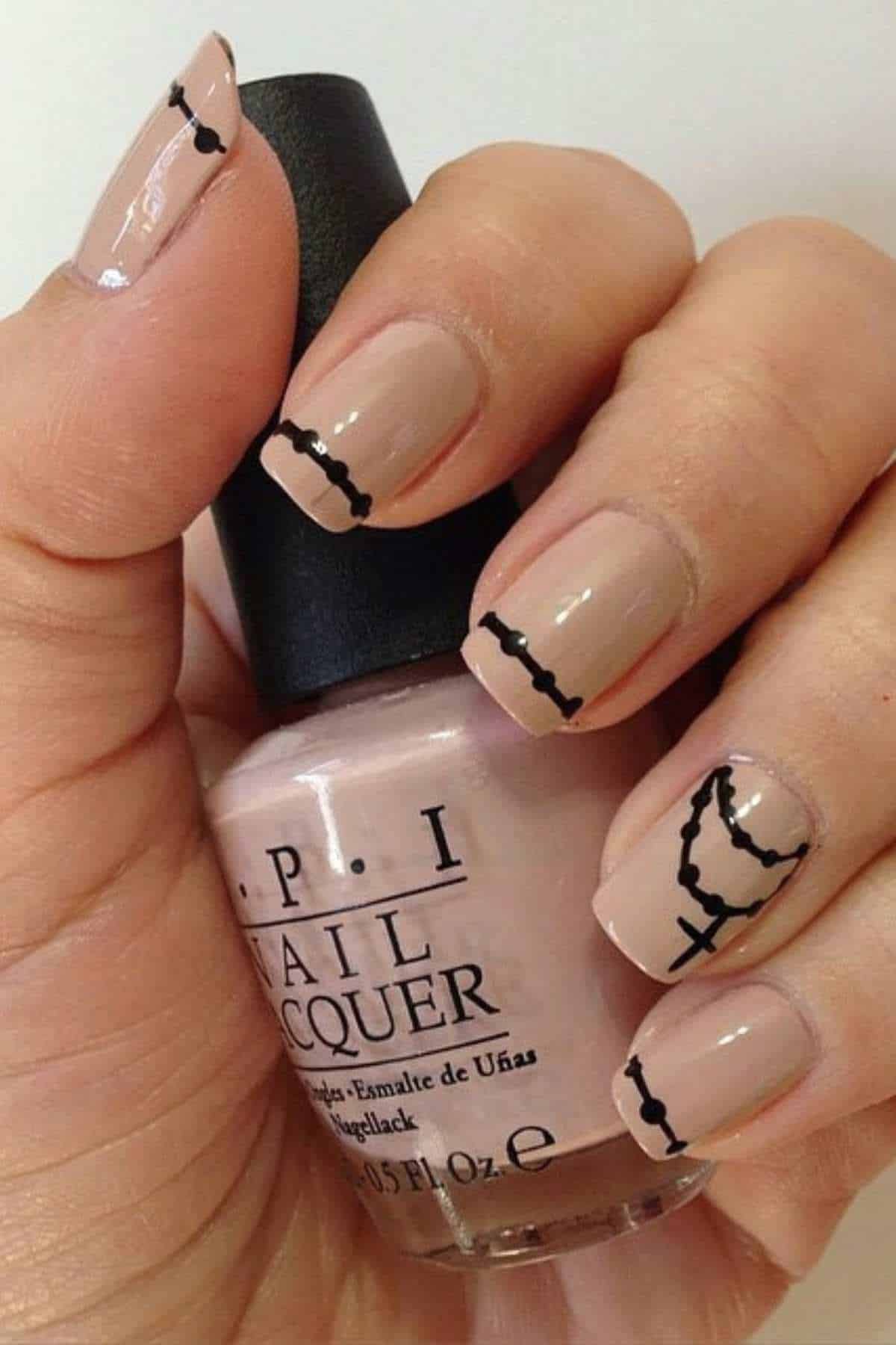 A hand with nude polished nails features black line art of a rosary and cross design, holding an OPI nail lacquer bottle.