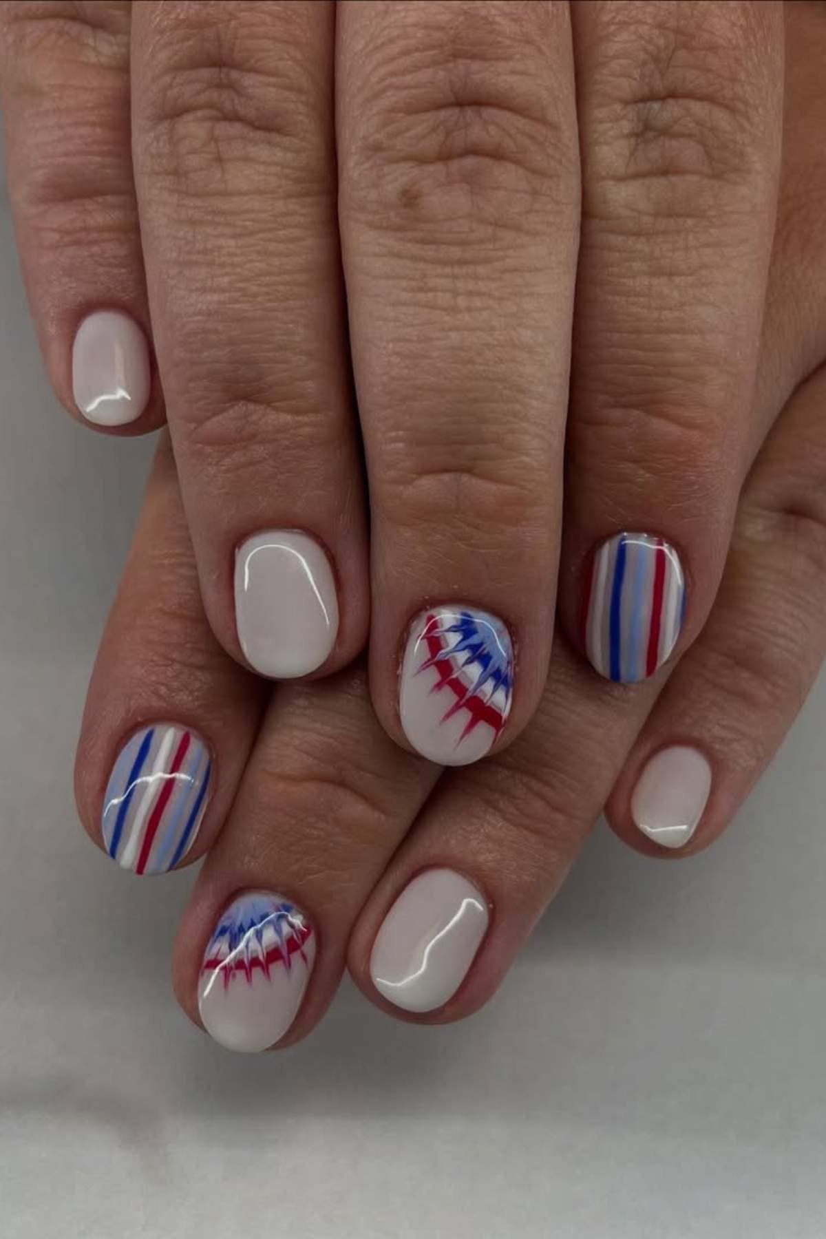Red, white, and blue striped and abstract pattern nails.